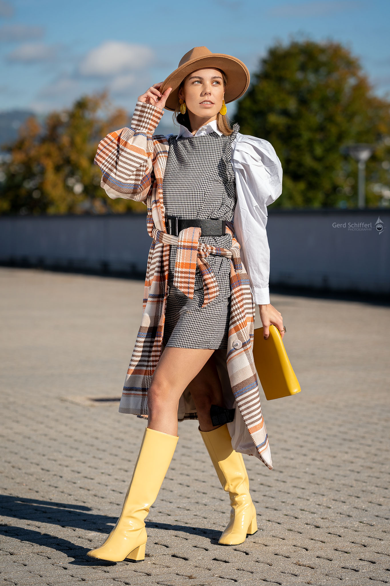 Lifestyle, Fashionaufnahme mit Herbstmode, weiße Bluse, Businessrock, gestreifter Mantel und gelbe Stiefel